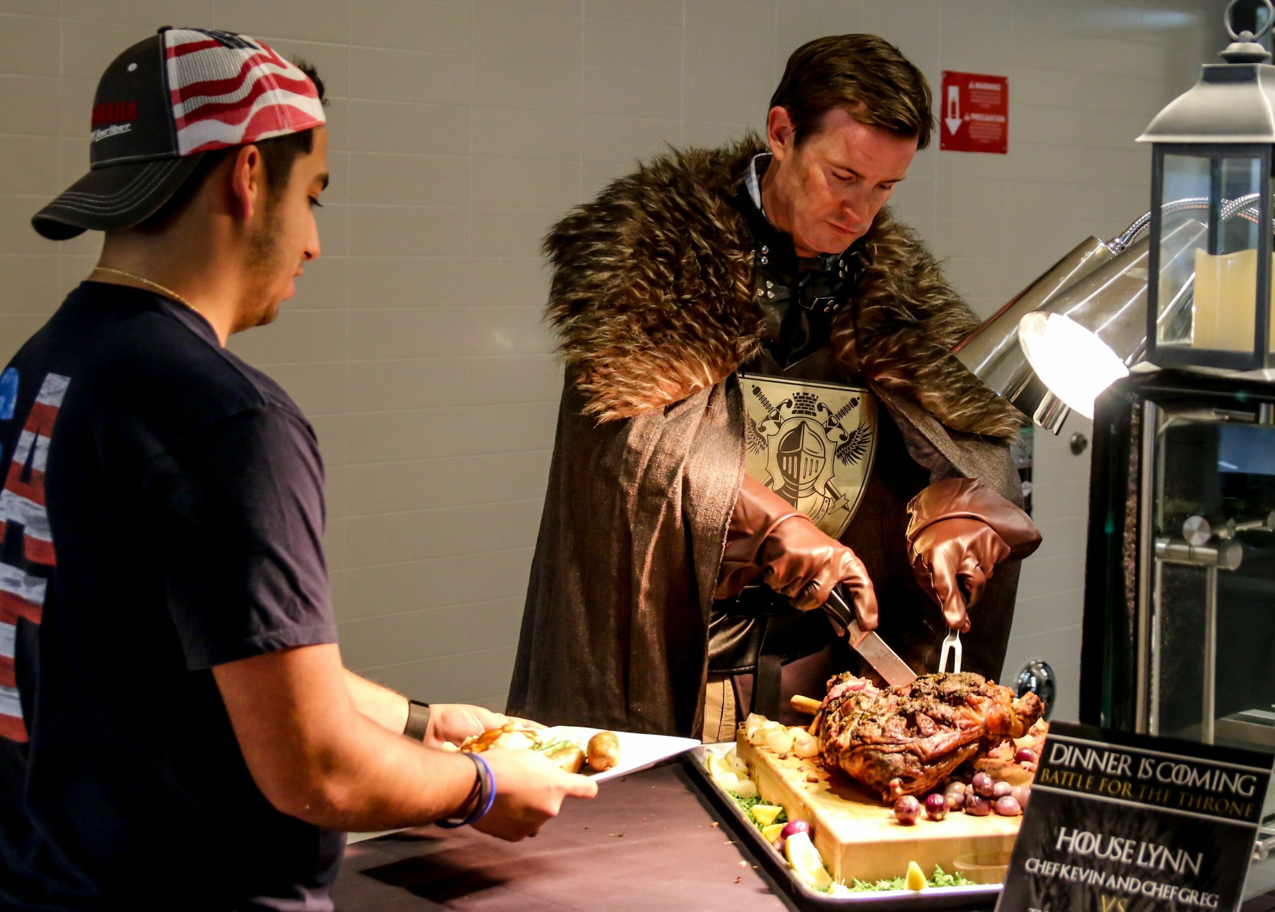 Game of Thrones hero Jon Snow (played by Lynn University President Kevin Ross) slices leg of lamb for a student during the Florida school's Battle Royale cooking competition. 
