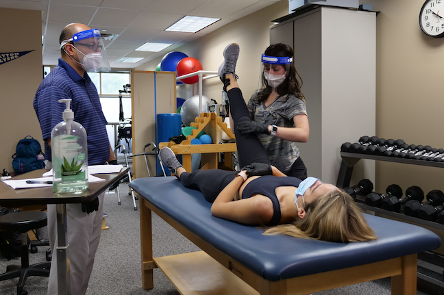 A University of Dayton graduate student practices stabilizing another student's knee in an accelerated physical therapy 'boot camp' being held on campus this spring.